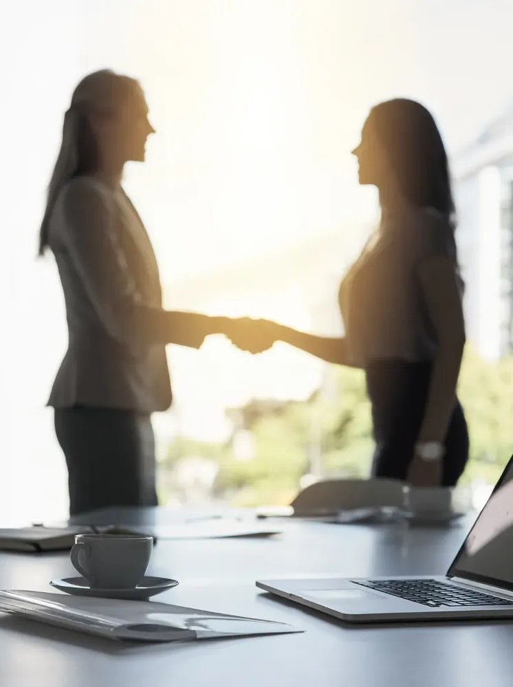 Femmes se serrant la main dans un bureau